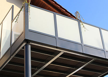 Balkonfront aus schwarzem Metallmaterial und Fensterelementen.